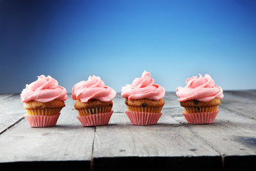 Tasty cupcakes on wooden background. Birthday cupcake in pink color