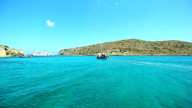 Greece. Beautiful sea coast against the background of mountains. View of the sea from the boat. Boat sails past the island of Spinalonga, location of the last leper colony in the whole of Europe