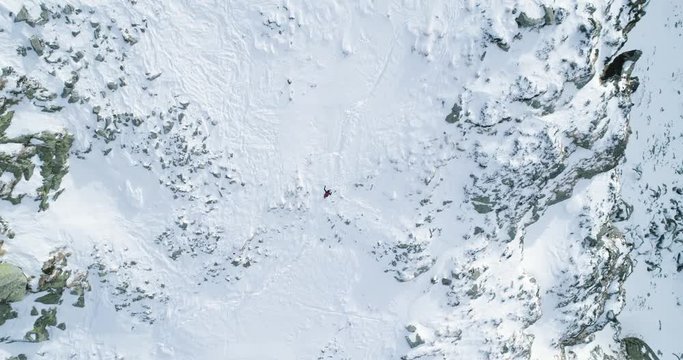 Overhead aerial top view over winter snowy mountain with mountaineering skier people walking up climbing.snow covered mountains ice glacier.Winter wild nature outdoor.4k drone straight-down flight