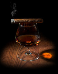 a smoky aromatic cigar and a glass of cognac