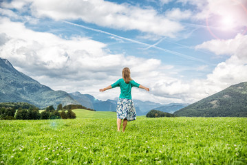 Young woman staying on the green field