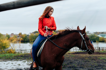 Obraz premium beautiful girl rides a horse in a village in the fall