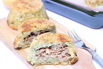 Potato pie with tuna on wooden chopping board