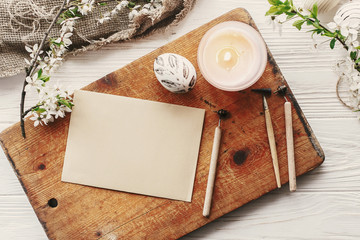 modern easter egg top view on rustic background with fresh spring flowers. happy easter greeting card with space for text. stylish painted egg. flat lay . craft paper