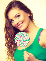 Woman charming girl with lollipop candy