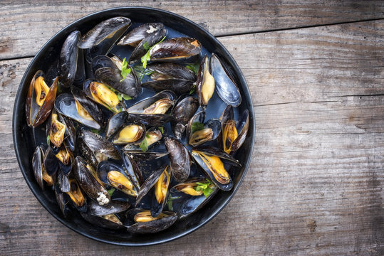 Traditional barbecue Italian blue mussel in white wine as top view in a casserole