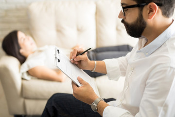 Psychologist making notes during a psychotherapy session