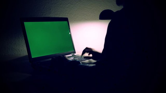 Mann arbeitet nachts am Laptop im Darknet