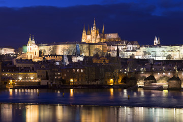 Fototapeta na wymiar Evening colorful snowy Christmas Prague Lesser Town with gothic Castle and Charles Bridge, Czech republic