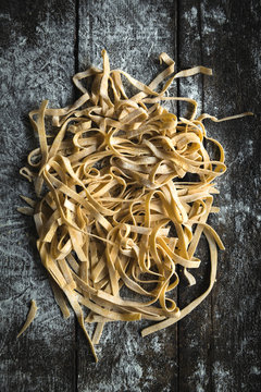 Italian traditional tagliatelle splashed on the wooden table