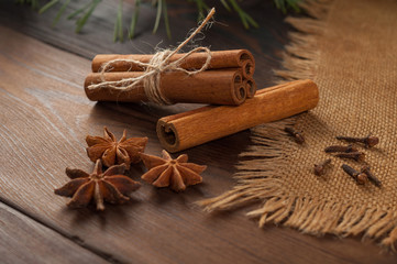 Cinnamon sticks and anise on sackcloth on a wooden background