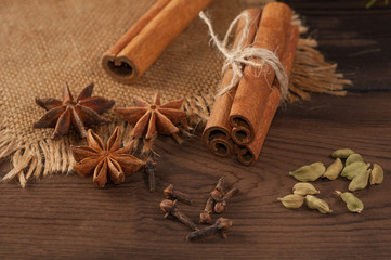 Cinnamon sticks and anise on sackcloth on a wooden background