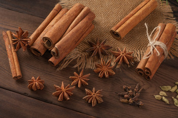 Cinnamon sticks and anise on sackcloth on a wooden background