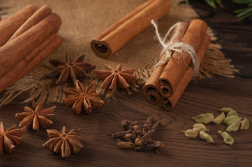 Cinnamon sticks and anise on sackcloth on a wooden background