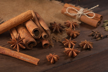 Cinnamon sticks and anise on sackcloth on a wooden background
