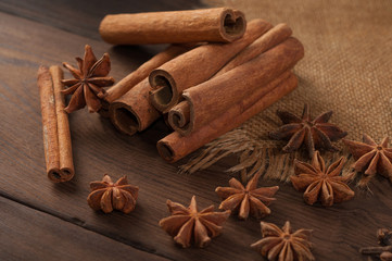 Cinnamon sticks and anise on sackcloth on a wooden background