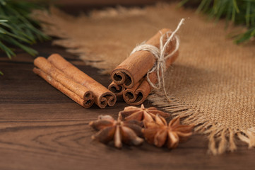Cinnamon sticks and anise on sackcloth on a wooden background