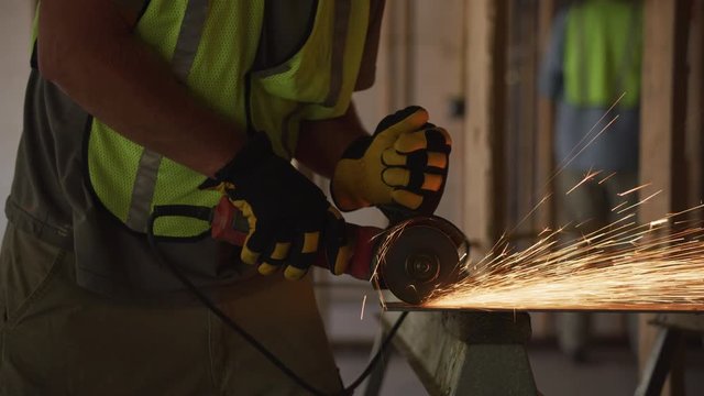 Construction worker grinding metal and making sparks