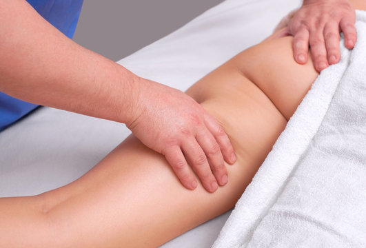 The masseur makes Anti-cellulite massage on the buttock and thighs of the patient. Treatment of excess weight.