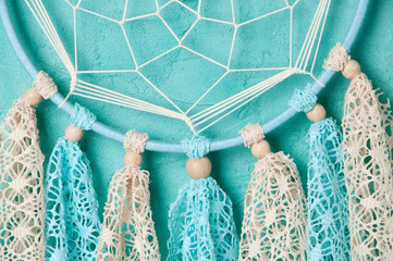 Dream catcher on aquamarine wall background
