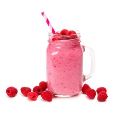 Raspberry smoothie in a mason jar glass with straw and scattered berries isolated on white