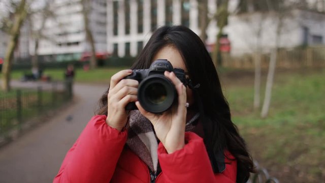 Young asian female taking photos of the viewer
