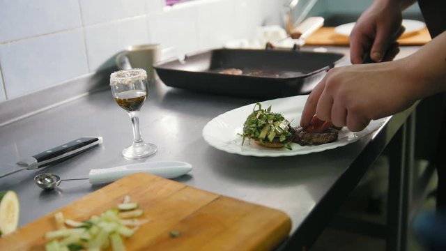 Chef serves meat on the plate