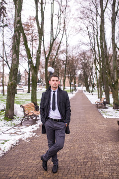 Portrait of a young businessman in a winter park