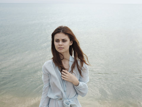 Serious Caucasian woman standing near ocean