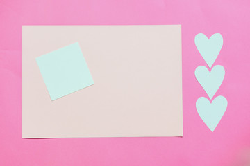 Paper pink background with empty notes. The concept of Valentine Day or bloggers. Flat Lay, top view