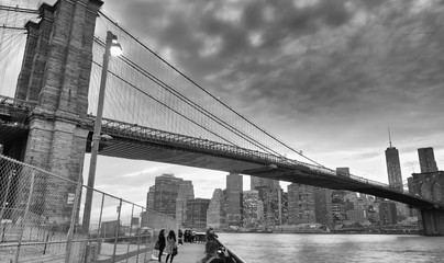 Black and white view of Brooklyn Bridge and Downtown Manhattan at sunset