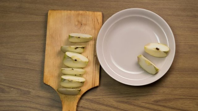 Cutting fruit on a cutting board, laying them in a plate, top view. Stop motion animation 