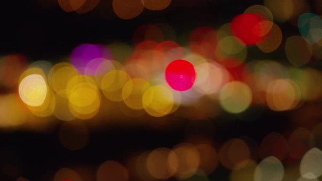 Aerial shot goes out of focus to make blurred lights at night