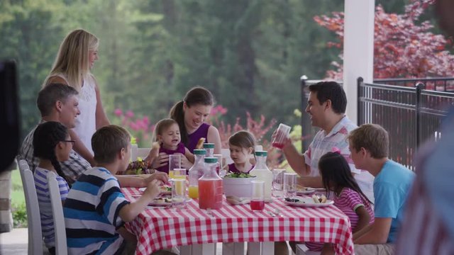 Group of people eating and enjoying a backyard barbeque