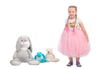 little girl posing together with big toys