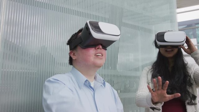 Two young people wearing VR goggles