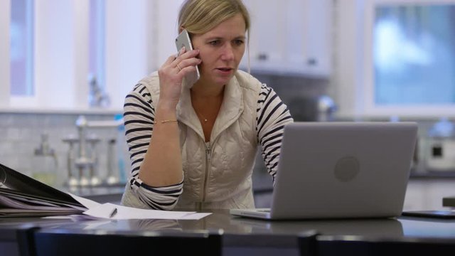 Woman in kitchen with laptop computer working from home