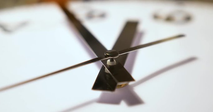 An extreme close up of the hands on a typical household wall clock. Shallow depth of field.	 	