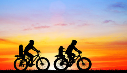 Fototapeta premium silhouette Mother ride a bike with daughter on blurry sunrise