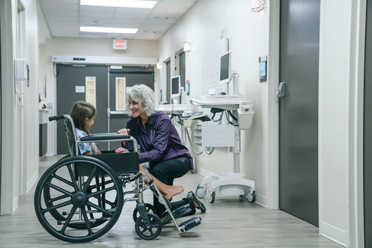 Doctor comforting girl in wheelchair