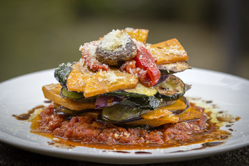 Vegetable stack - pumpkin, zucchini, red capsicum, eggplant and mushroom cooked in a tomato, onion, and garlic sauce topped with parmesan cheese