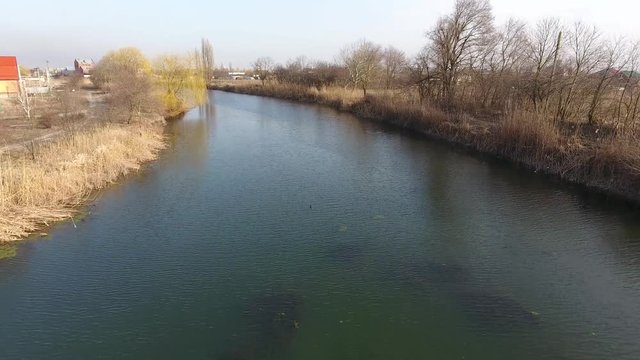 River eric current in the village in the spring. Shallow river, slowly flowing in the village