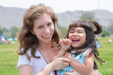 Fototapeta premium Happy biracial family - caucasian mom and her latin daughter.
