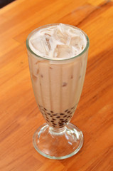 Milk tea with pearls on wooden table.