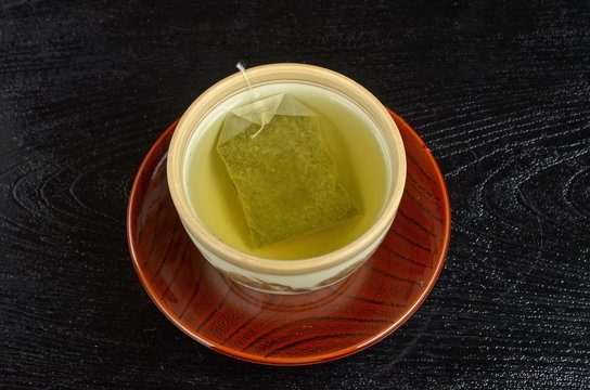 Green tea bag in the cup 