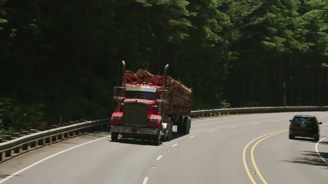 Oregon circa-2107, Logging truck driving on highway in Oregon forest.