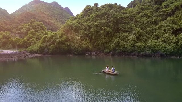 Drone Removes from Man Sailing on Boat with Girl in Bay Ha Long