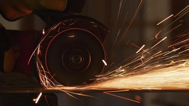 Construction worker grinding metal and making sparks, closeup