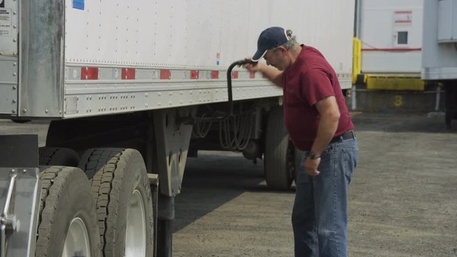 Truck driver preparing trailer.  Fully released for commercial use.