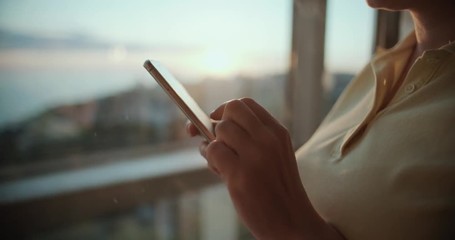girl in the elevator with a panoramic view uses a smartphone